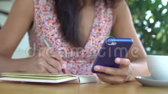女人用手机和笔记本来学习英语视频的预览图