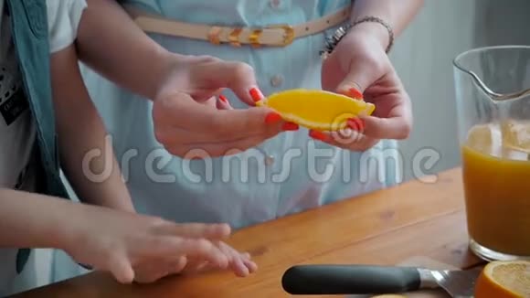 妈妈给儿子切水果在木切割板上切片橘子健康美味的早餐美国家庭视频的预览图