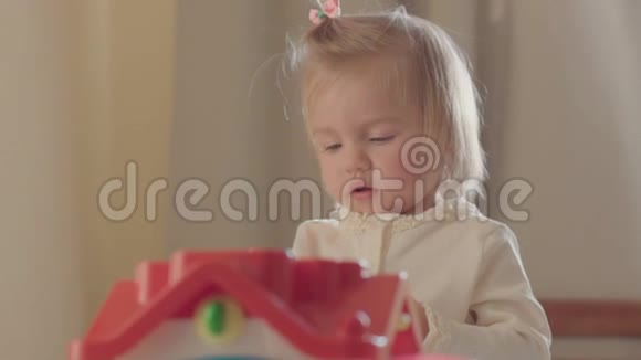 小女孩在父母的床上玩五颜六色的玩具视频的预览图