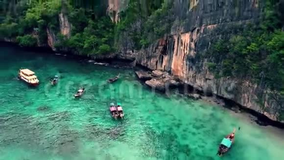 在绿松石蓝色海水附近有绿色热带森林的巨大岩石海景4k鸟瞰视频的预览图