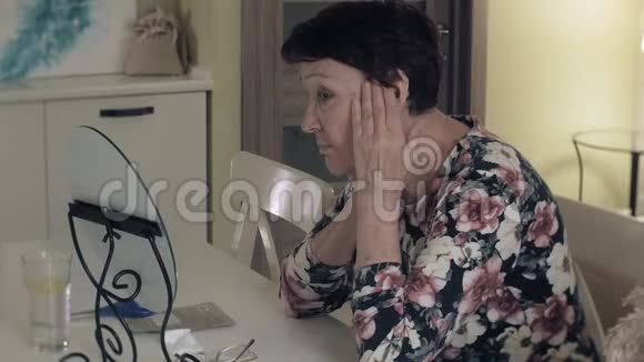 一位老妇人看着镜子里的皱纹舒缓皮肤整形手术和胶原蛋白注射现实视频的预览图