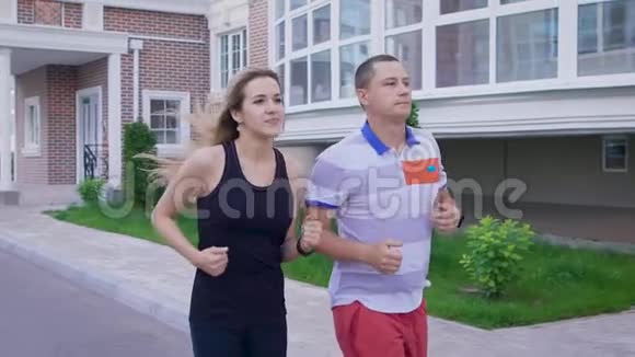 两个人在街上慢跑在城里跑步男人和女人做运动视频的预览图
