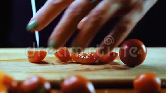 一个女人正在用菜刀切樱桃西红柿慢动作视频的预览图