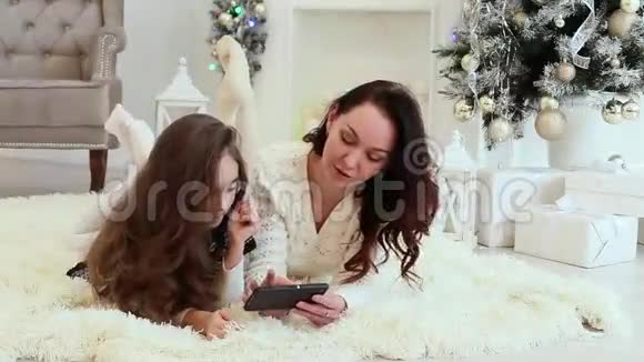 快乐的母亲和女儿使用智能手机圣诞装饰的内部视频的预览图