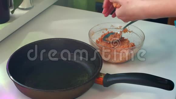 一位女士正在用鲑鱼肉准备小片做小坯切小片放在煎锅里视频的预览图
