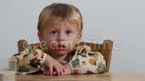 坐在桌子旁的小男孩的肖像视频的预览图