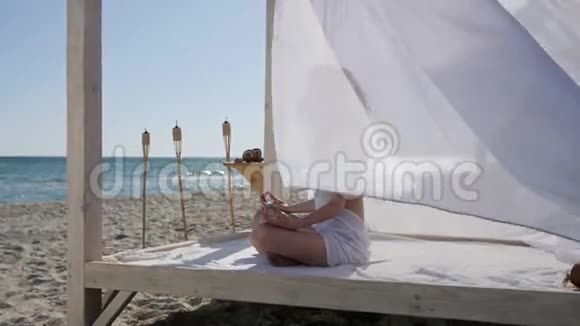 女孩在海滩上打坐暑假在度假胜地女人在河堤上做瑜伽视频的预览图