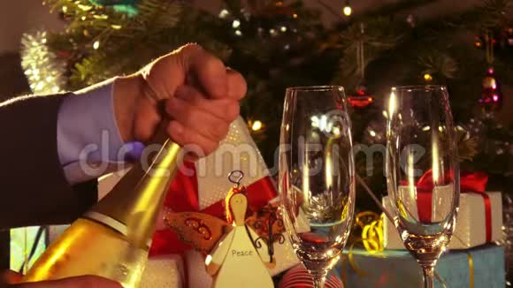 圣诞快乐一个人打开一瓶起泡葡萄酒4k视频的预览图