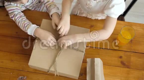 小女儿和小男孩打开盒子厨房里有甜点糖果视频的预览图
