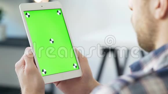 年轻人使用带有绿色屏幕的智能手机进行交流视频的预览图