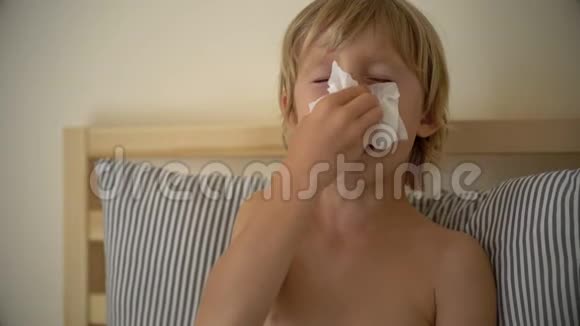 一个生病的小男孩躺在床上的超慢镜头婴儿流感概念视频的预览图