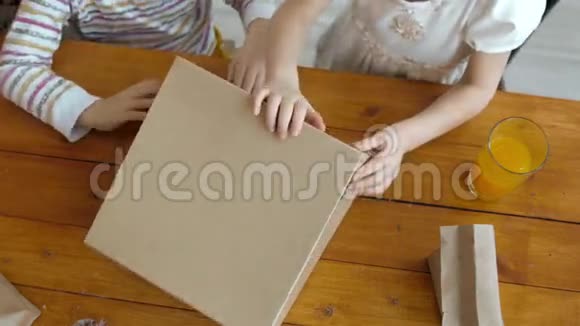 小女儿和小男孩打开盒子厨房里有甜点糖果视频的预览图