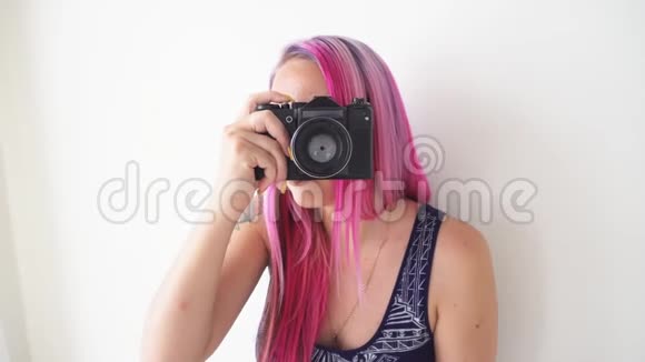 粉色头发的女孩在老式相机上拍照视频的预览图