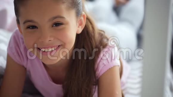 快乐的小女孩躺在床上视频的预览图