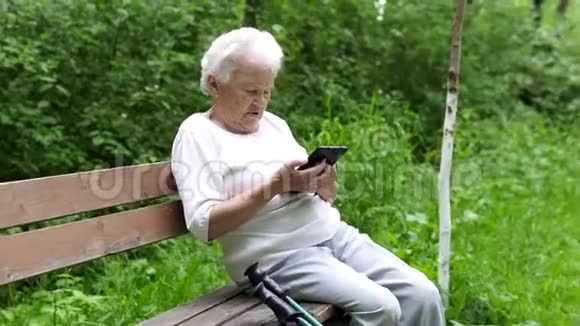 老奶奶看着互联网智能手机视频的预览图