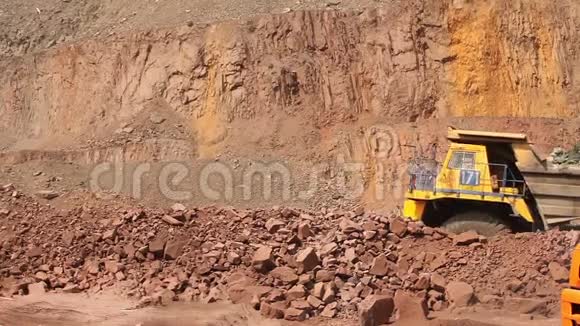 一辆翻斗车在一个采石场沿着道路行驶一辆黄色的采矿自卸卡车一幅全景图视频的预览图