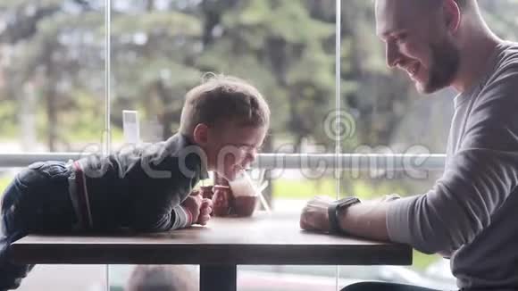 小男孩看着父亲手上的智能时钟视频的预览图