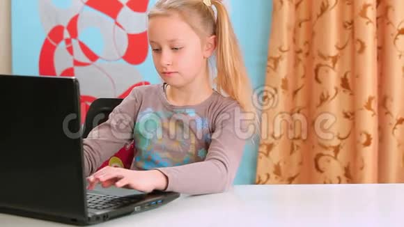 女孩在笔记本电脑上玩视频的预览图