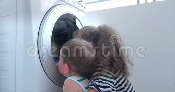 可爱的孩子在洗衣机里看气缸旋转机概念洗衣机工业视频的预览图