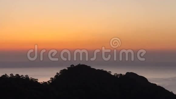 4K景区日出背景太阳升起日出的时间流逝波涛汹涌的大海和群山视频的预览图