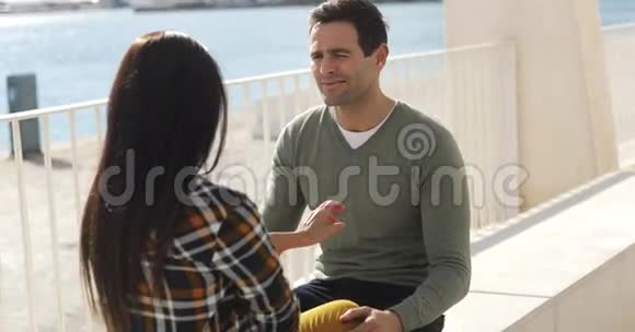 坐在码头边聊天的年轻男女视频的预览图