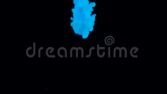 真正的蓝漆滴在水里墨水在水下旋转黑色背景上孤立的墨迹碰撞云视频的预览图