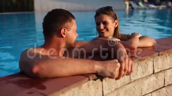 年轻夫妇正一起在游泳池里游泳视频的预览图