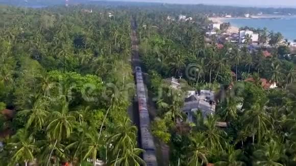 老火车乘着棕榈树和别墅穿过热带视频的预览图