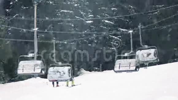 雪地滑雪者坐在升降椅上视频的预览图