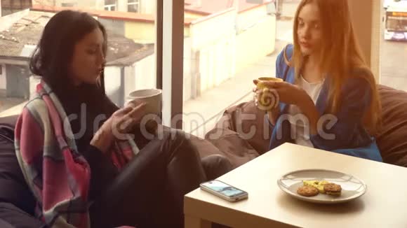 两个漂亮的女孩坐着喝茶讨论视频的预览图