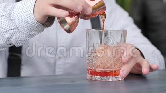 酒吧老板把酒加到酒吧桌上的冰中酒吧老板用冰块将果汁倒入杯中视频的预览图