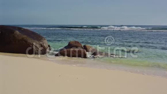海洋在塞舌尔海岸冲刷着巨大的石头视频的预览图