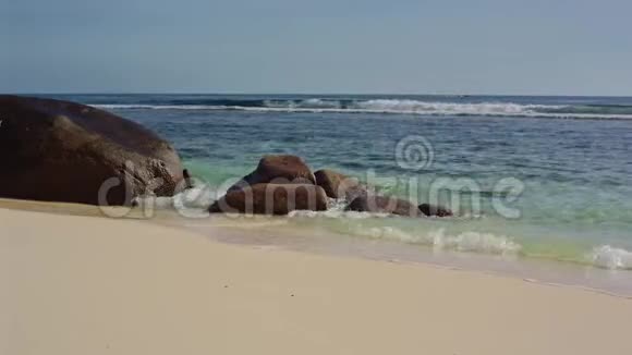 海洋在塞舌尔海岸冲刷着巨大的石头视频的预览图