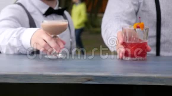 酒吧服务员提供酒精特写酒吧服务员在酒吧柜台上装饰的彩色饮料手中的酒吧服务员冰镇饮料视频的预览图