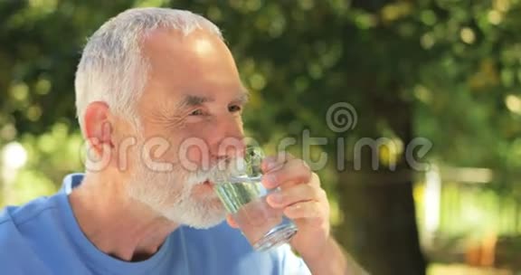 老人在花园里用玻璃喝水视频的预览图