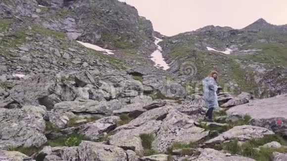 一位年轻的女徒步旅行者爬上山脉用相机拍摄风景罗马尼亚喀尔巴阡山脉视频的预览图