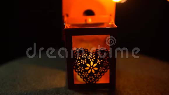 一个女人用红色手电筒在黑色背景上从火柴上点燃蜡烛视频的预览图