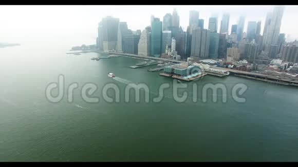 曼哈顿金融区远处的直升机从哈德逊河上拍摄船浮在上面视频的预览图