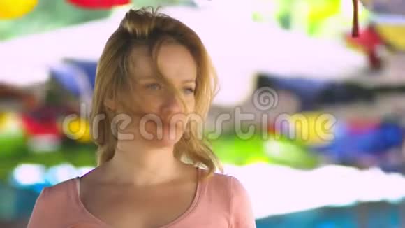 一位金发美女站在一个开放的空间里在一个刮风的日子里专注地看着相机副本视频的预览图