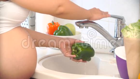 孕妇在厨房里洗和切胡椒视频的预览图