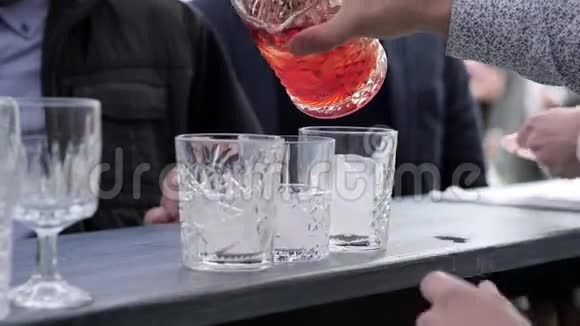 酒吧老板准备饮料双手调酒师把鸡尾酒倒入装有冰块的玻璃杯中酒吧老板把酒从玻璃杯中倒入视频的预览图