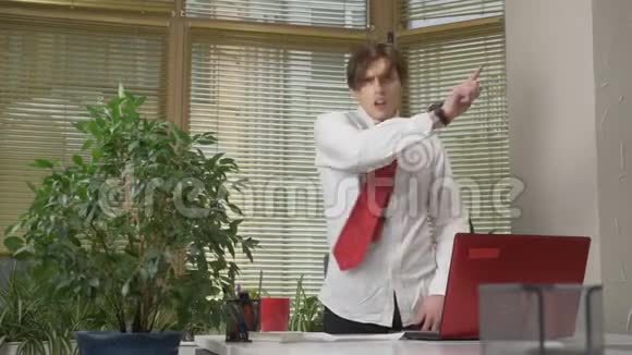 穿西装的年轻人在办公室里跳舞做滑稽的脸傻瓜快乐办公室工作概念60fps视频的预览图