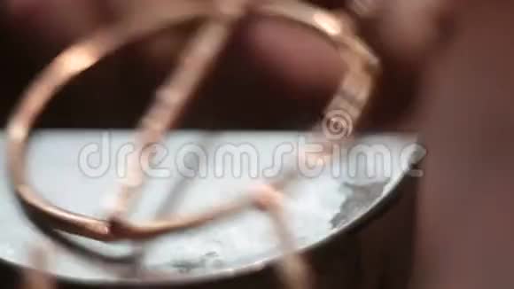 珠宝商把圆形铜制品放在铁架上有圆孔视频的预览图