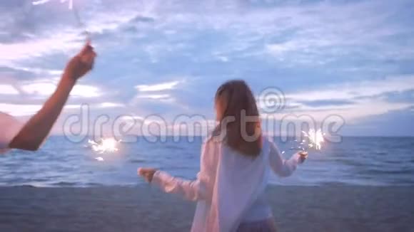 女孩们带着火花沿着海滩奔跑视频的预览图