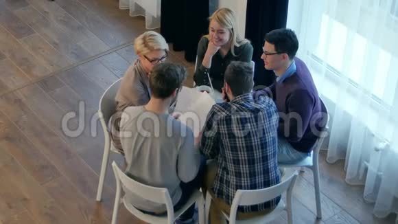 团队交流五个人坐在办公桌前微笑着讨论某件事视频的预览图