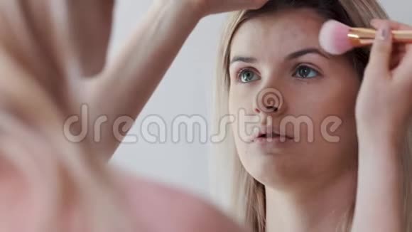 女人用大刷子涂化妆品的特写女孩在沙龙化妆涂粉在皮肤上视频的预览图