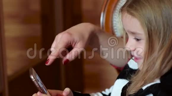 母女俩玩手机女孩打开手机上的应用程序玩手机游戏视频的预览图