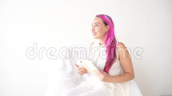 粉红头发的女孩在看书感受情感视频的预览图