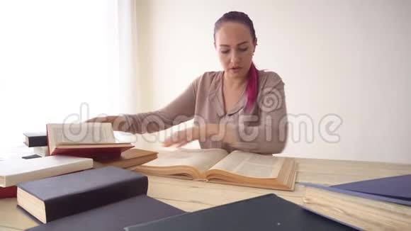 那个头发粉红的女孩正坐在桌子旁看书视频的预览图