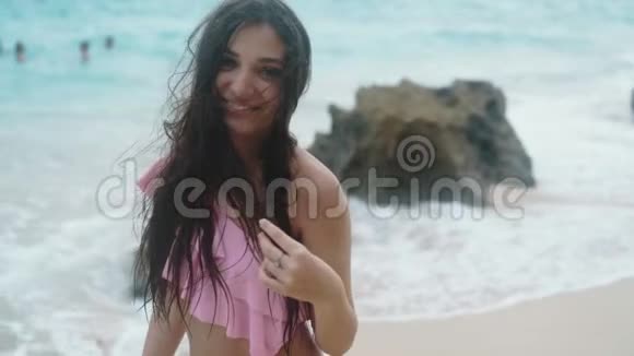 慢镜头穿着泳装的快乐女孩的肖像在海滩上放松背景是美丽的波浪Stealicam镜头视频的预览图